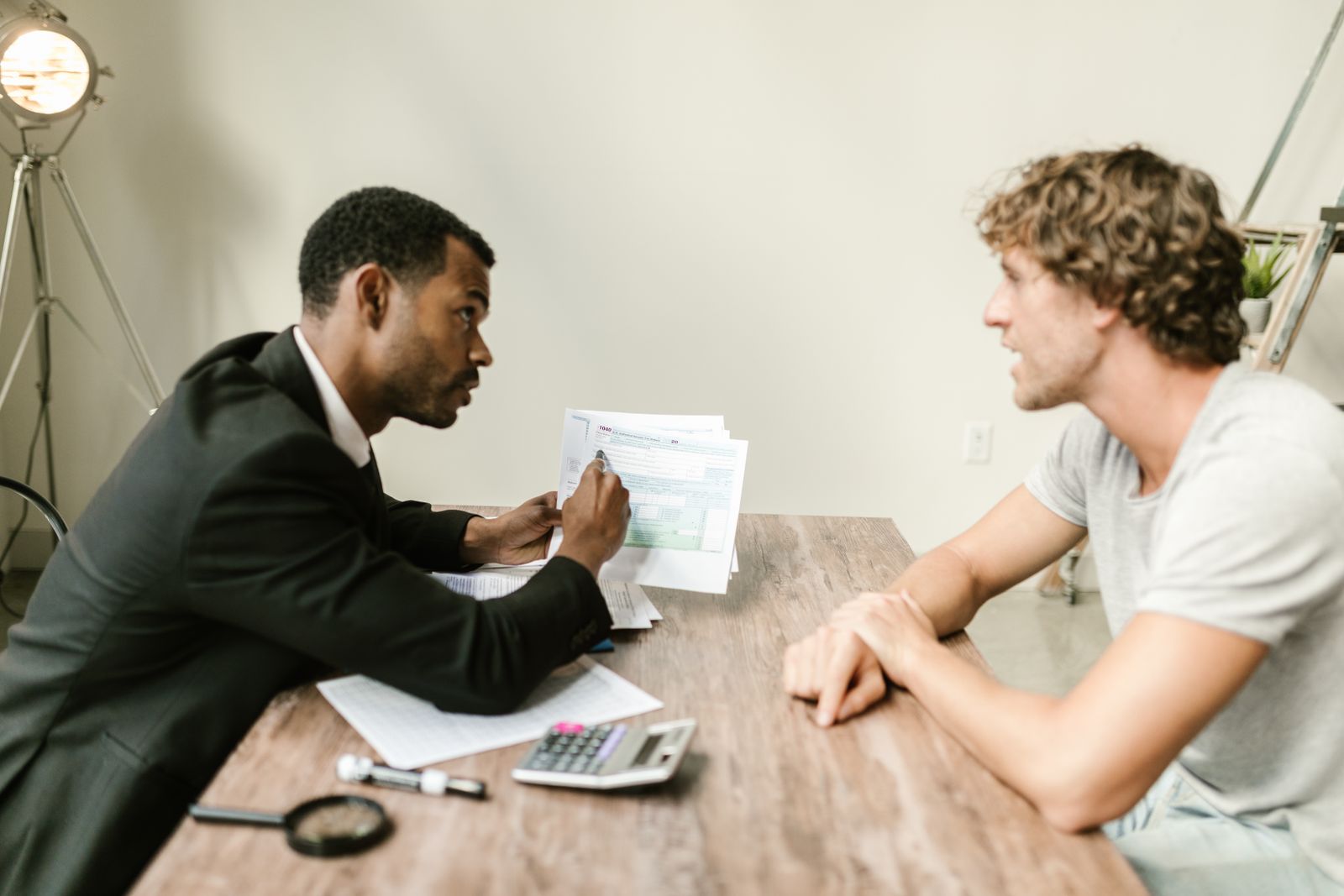 An advisor and a client discussing paperwork at a table